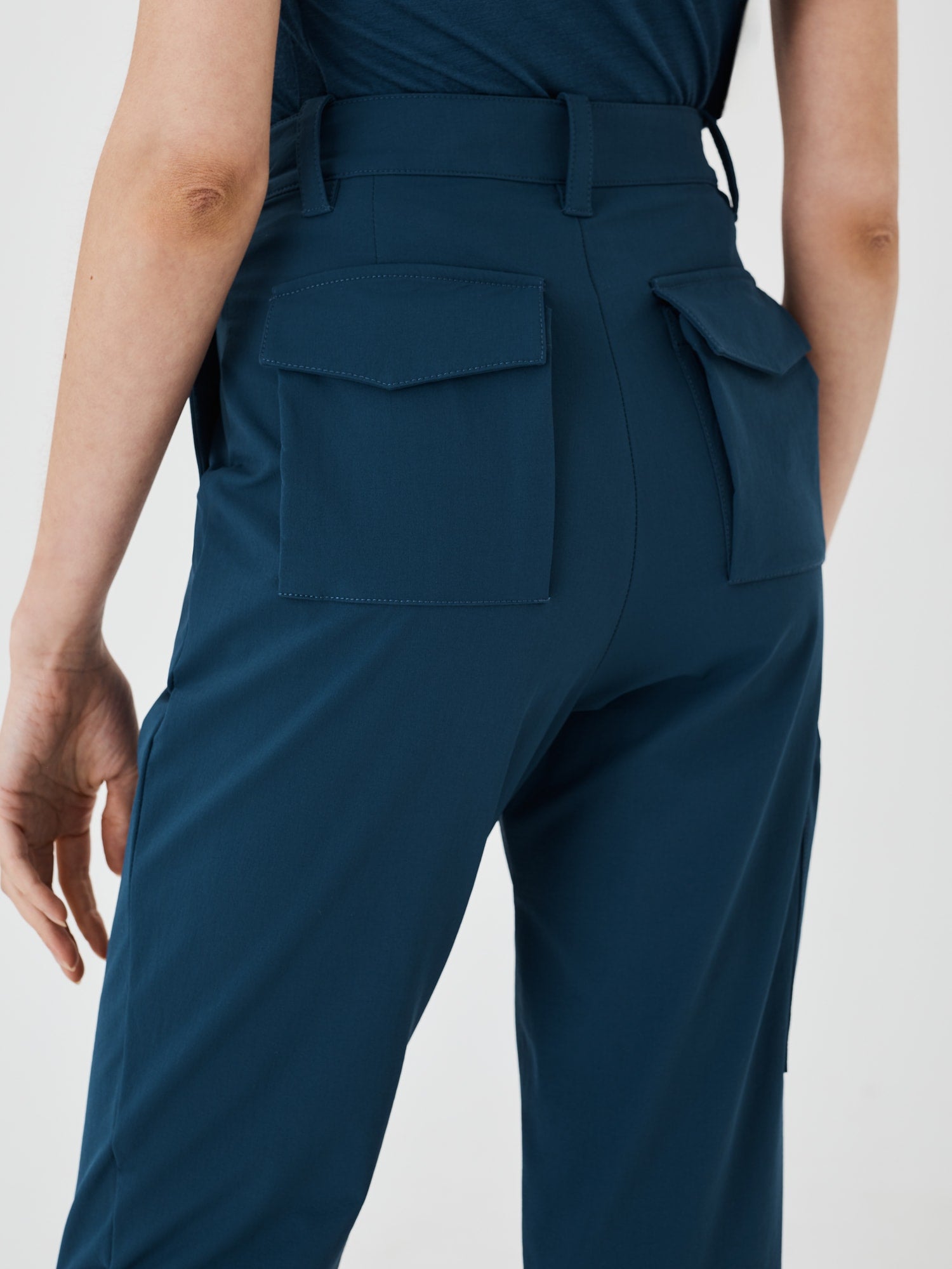 Close-up back view of blue Softshell Hiking Pants by Šumska, showing two gusseted back pockets with fine detailed stitching, highlighting the functional design and craftsmanship.