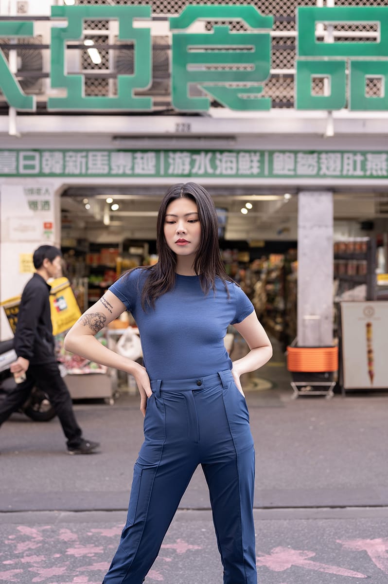 A woman in the city wearing a blue Merino classic t-shirt with blue softshell pants.