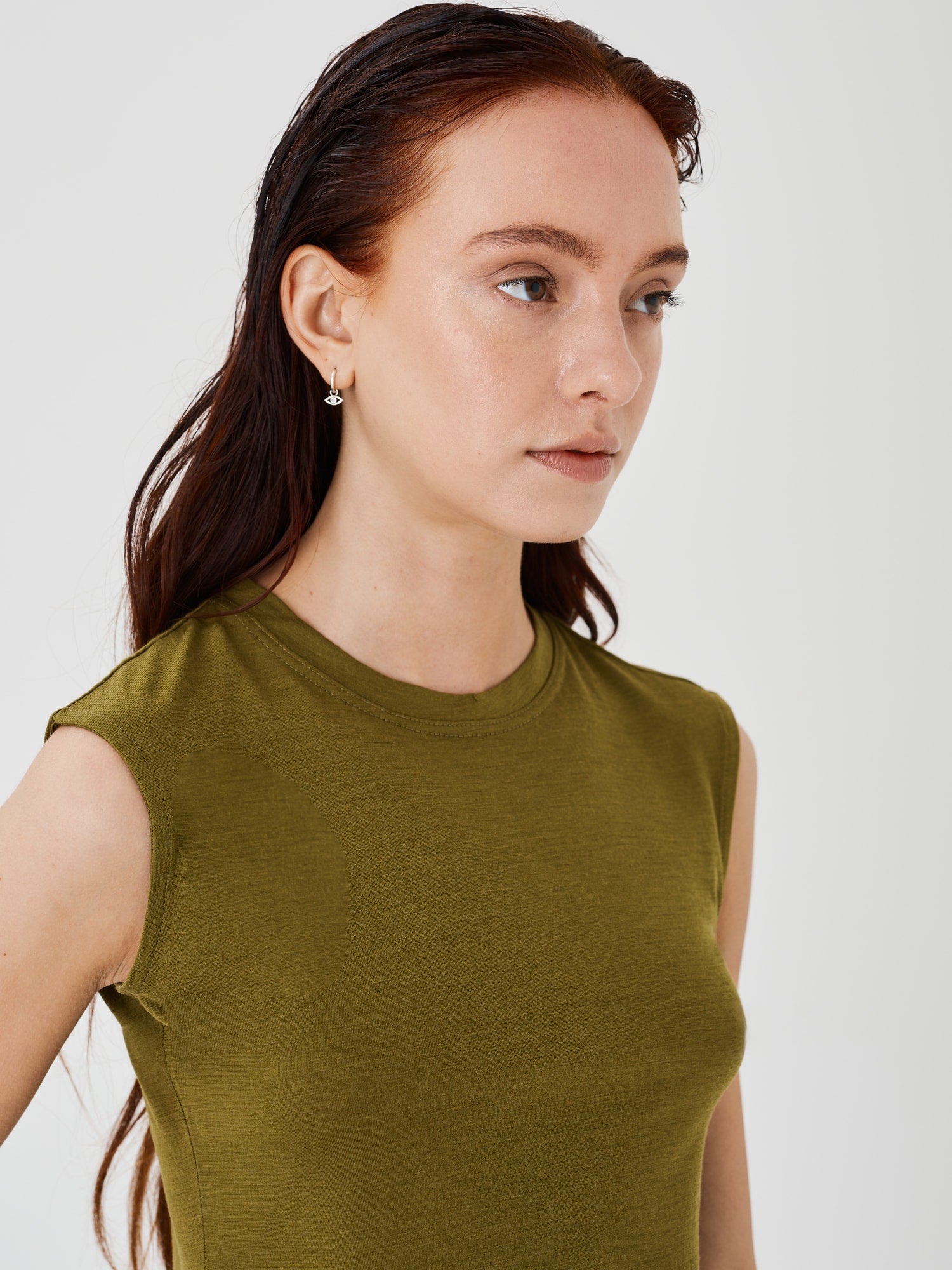 Zoomed-in view of a women's olive green merino wool sleeveless T-shirt by Šumska, highlighting the fine fabric texture and stitching details.