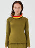 Close-up front view of an olive green merino wool Twiggy pullover jumper by Šumska, featuring a wide collar with vibrant red and yellow stripe panels, paired with olive green hiking pants.