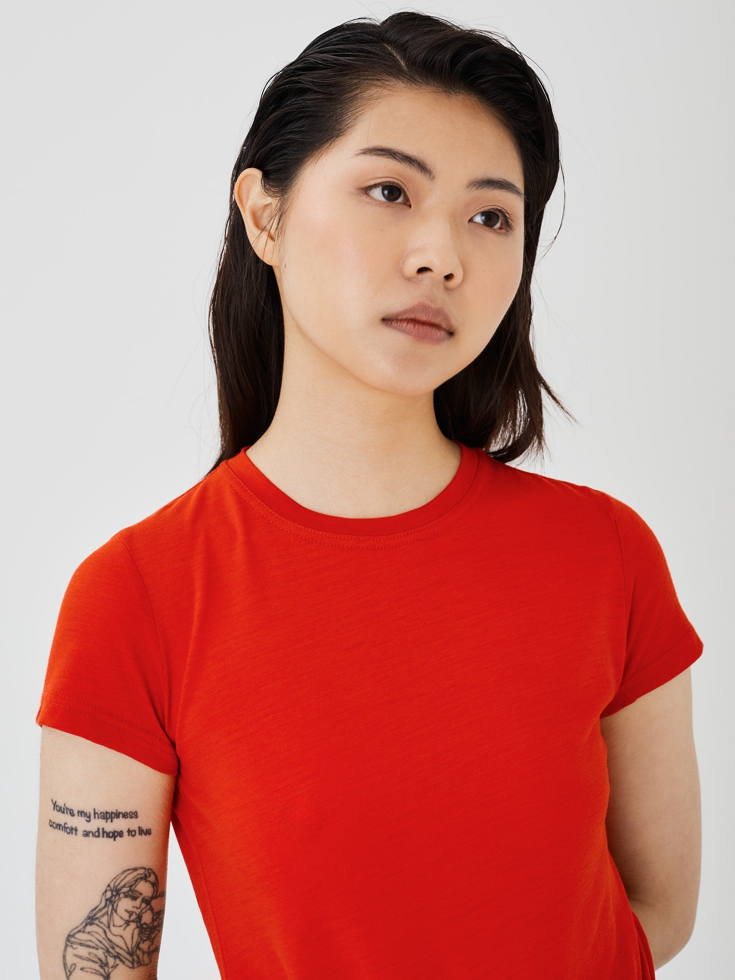 Zoomed-in view of a women's red merino wool classic T-shirt by Šumska, highlighting the fine fabric texture and stitching details.