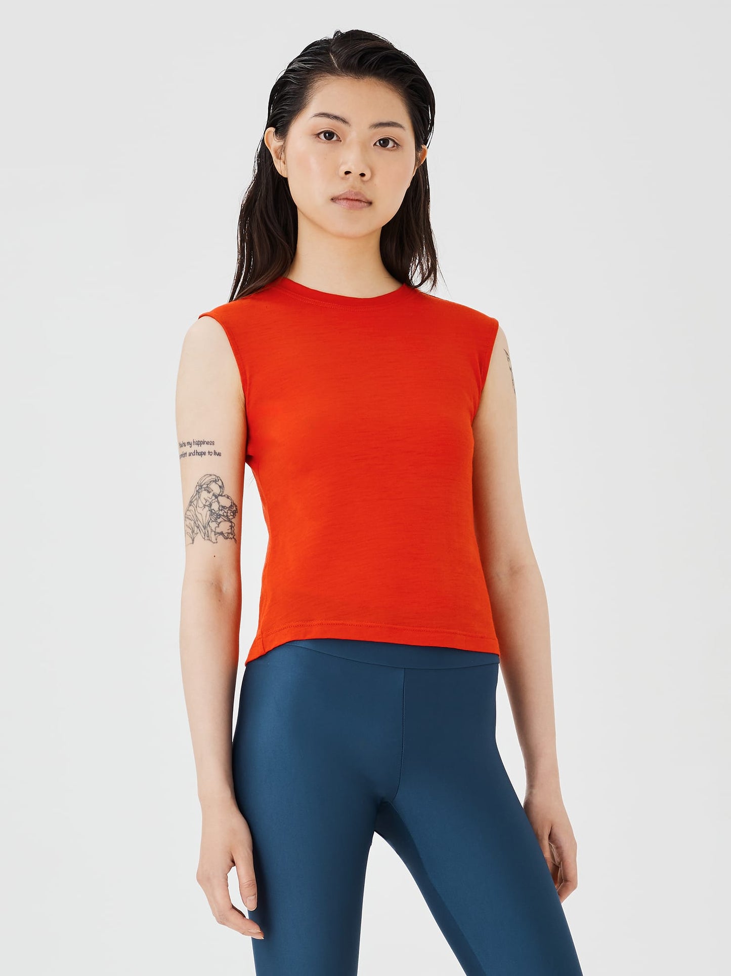 Close-up view of a women's red merino wool sleeveless T-shirt by Šumska, showcasing the fabric texture and smooth design.