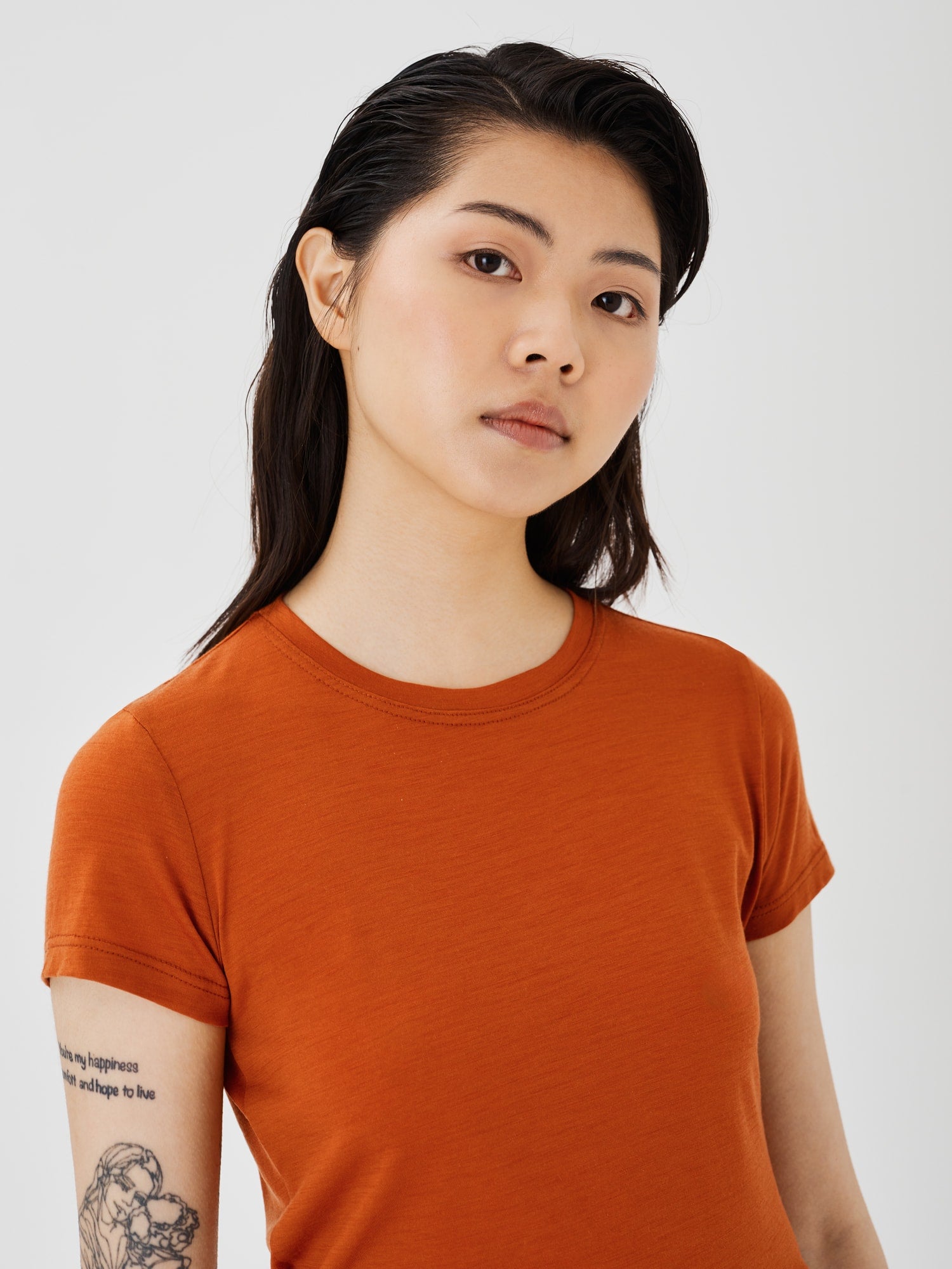 Zoomed-in view of a women's rust merino wool classic T-shirt by Šumska, highlighting the fine fabric texture and stitching details.