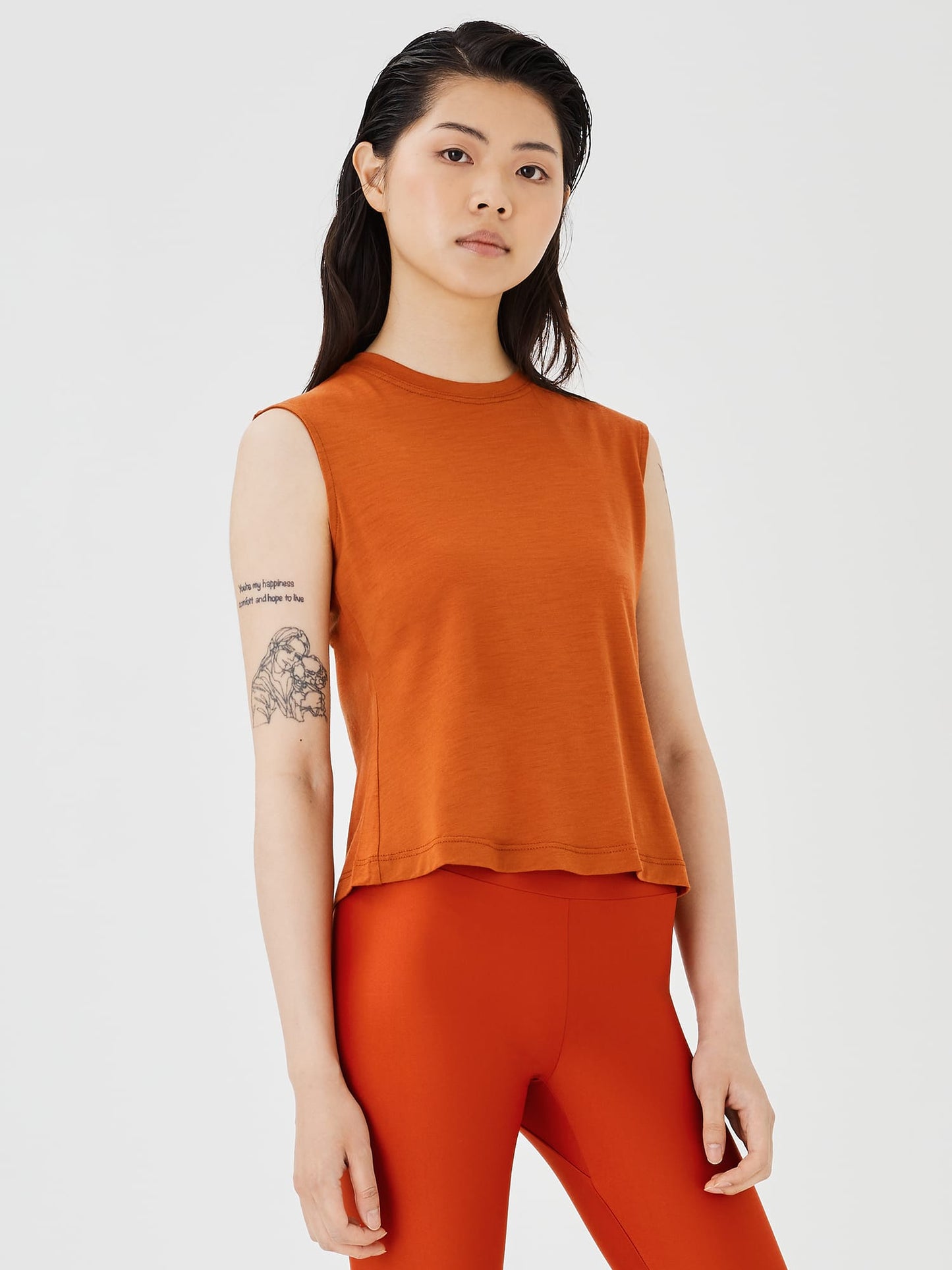 Close-up view of a women's rust merino wool sleeveless T-shirt by Šumska, showcasing the fabric texture and smooth design.