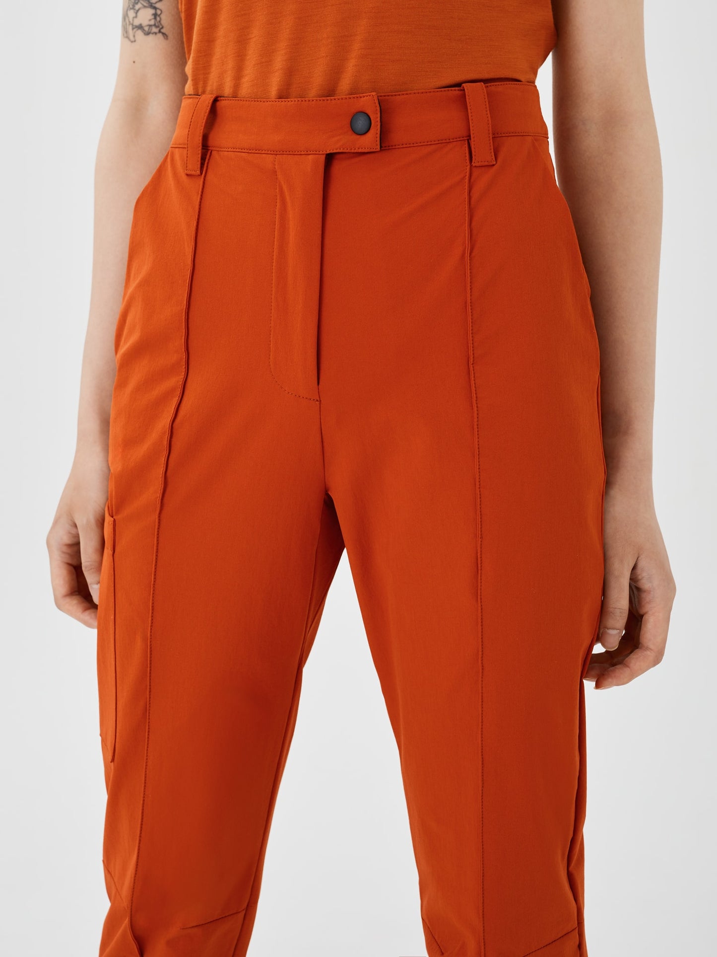 Zoomed-in view of rust-colored Softshell Hiking Pants by Šumska, highlighting the fine stitching, durable fabric, and functional design.