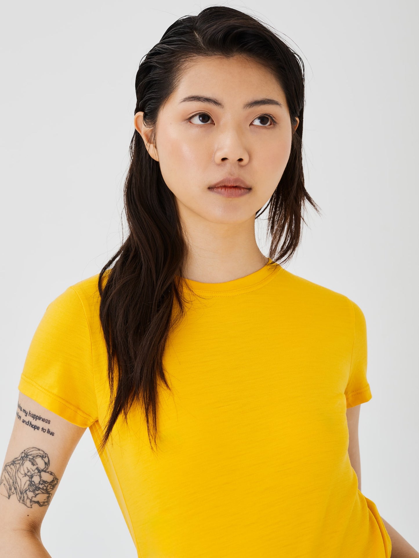 Zoomed-in view of a women's yellow merino wool classic T-shirt by Šumska, highlighting the fine fabric texture and stitching details.