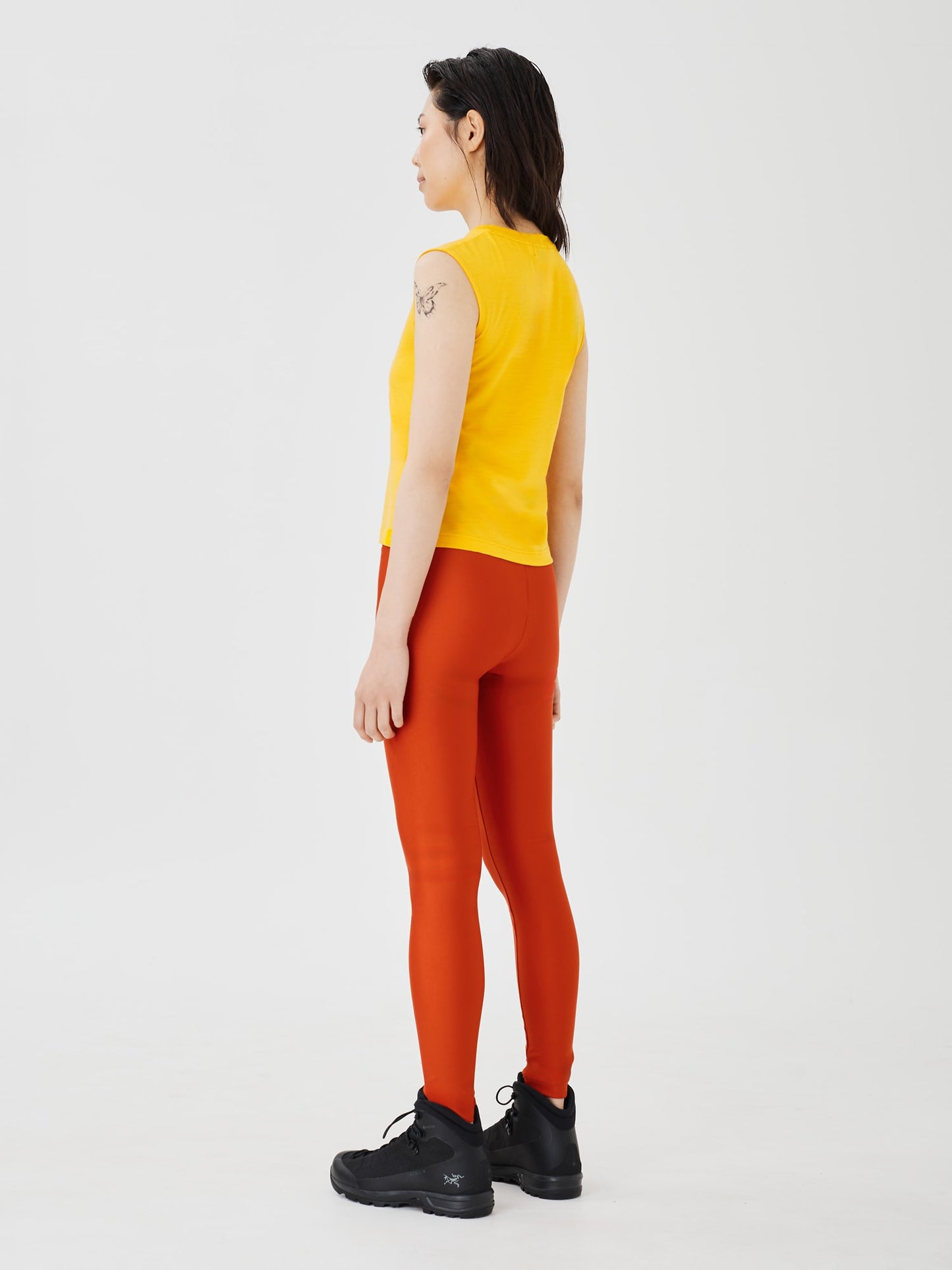 Back view of a women's yellow merino wool sleeveless T-shirt by Šumska, showcasing the smooth fit and lightweight design.